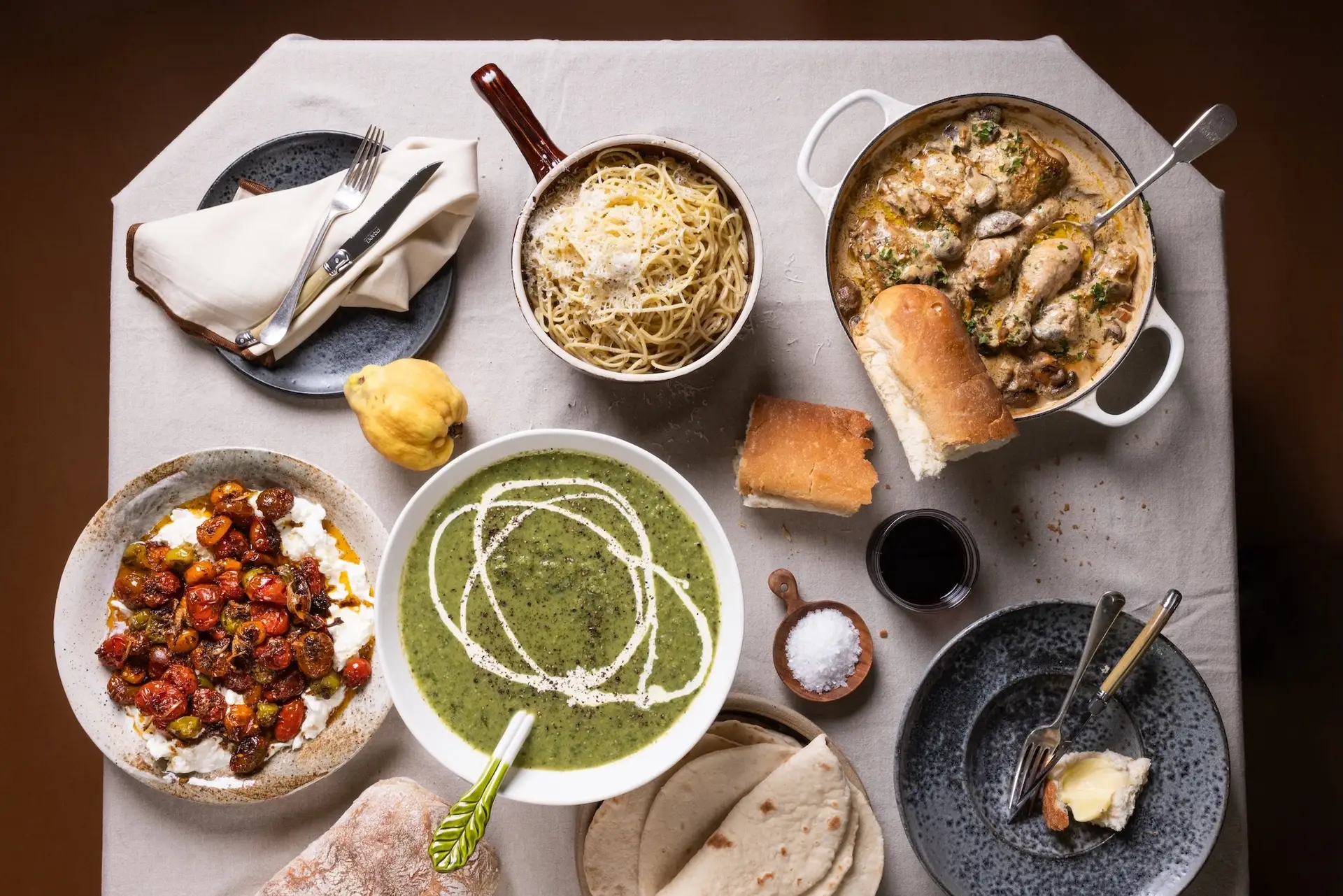 Table of spaghetti, chicken and mushroom pot, tomato and burrata, green soup and quince